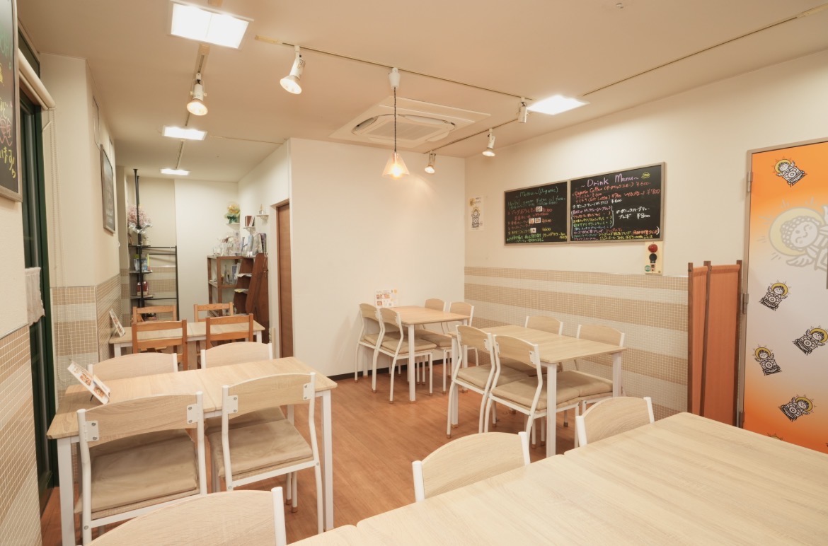 明るい木目のテーブルが並ぶ悟カフェの店内