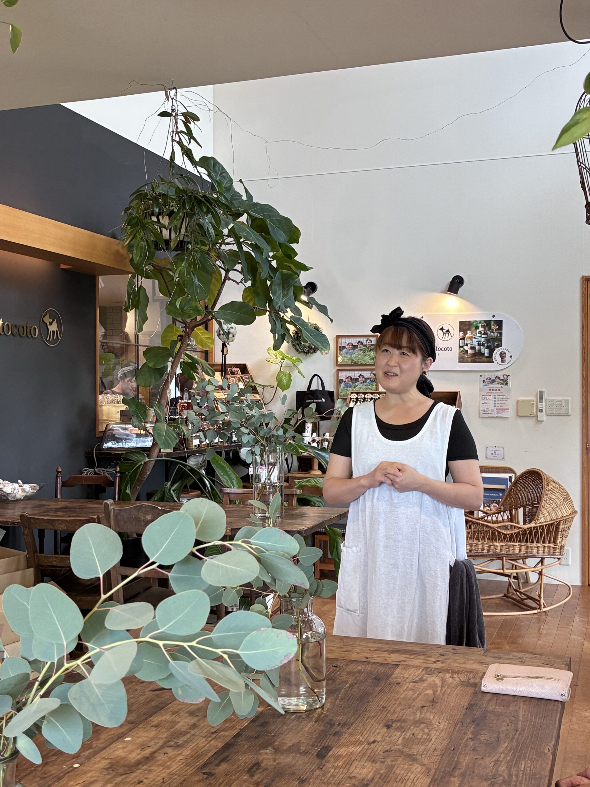 植物や商品が並ぶ店内で、お食事会の参加者に話をする奥田晶子さん